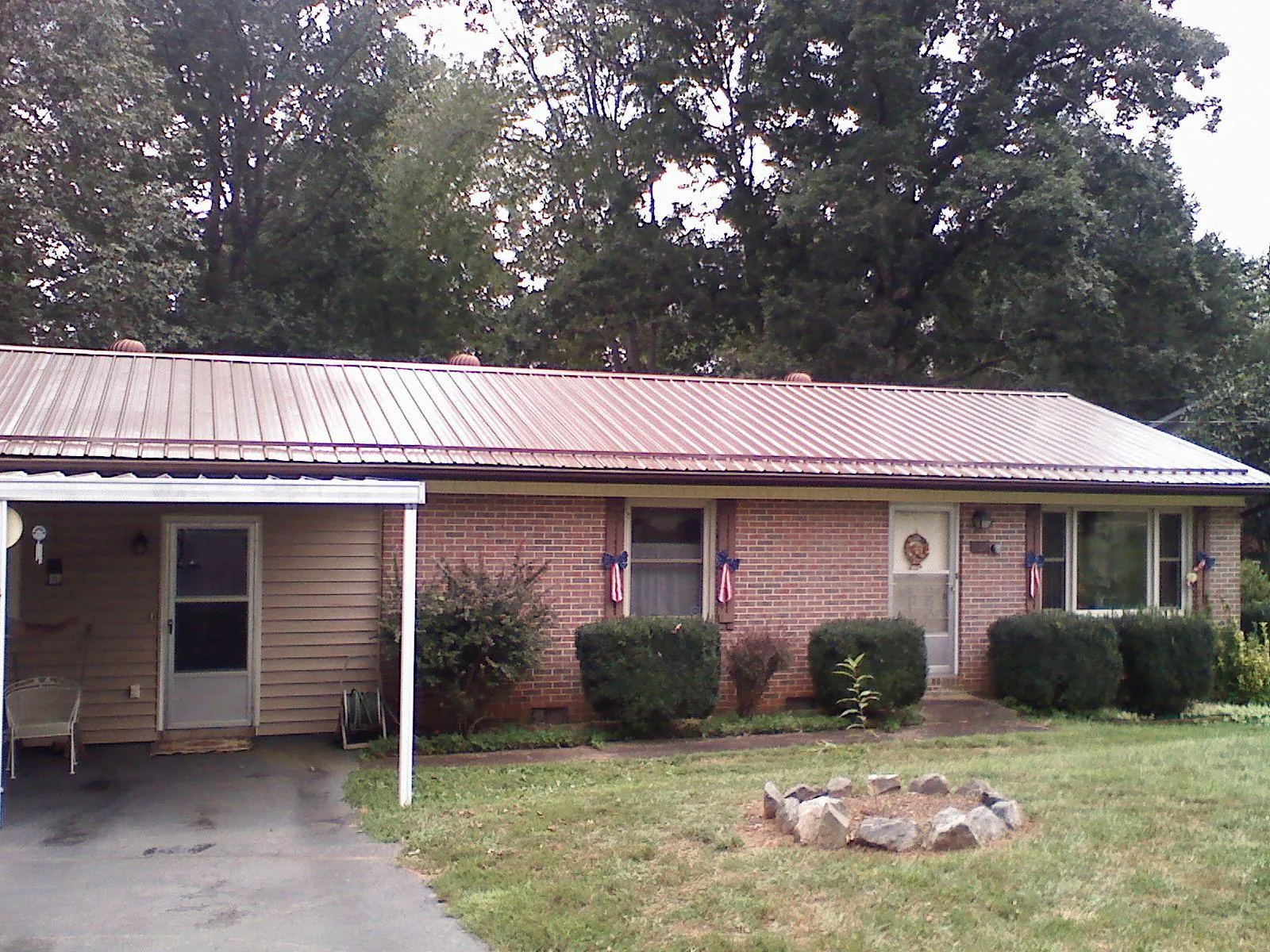 Bronze metal roof and carport on a brick ranch home — Roof Repair work by our crew in Emigrant